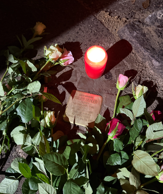Stolperstein mit Kerze und Rosen